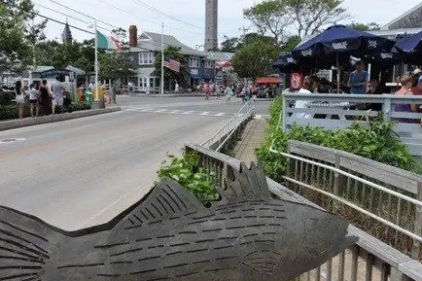 an empty park bench next to a fence